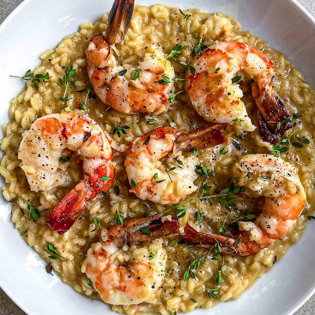 The most delicious king prawn orzo served in a while bowl.