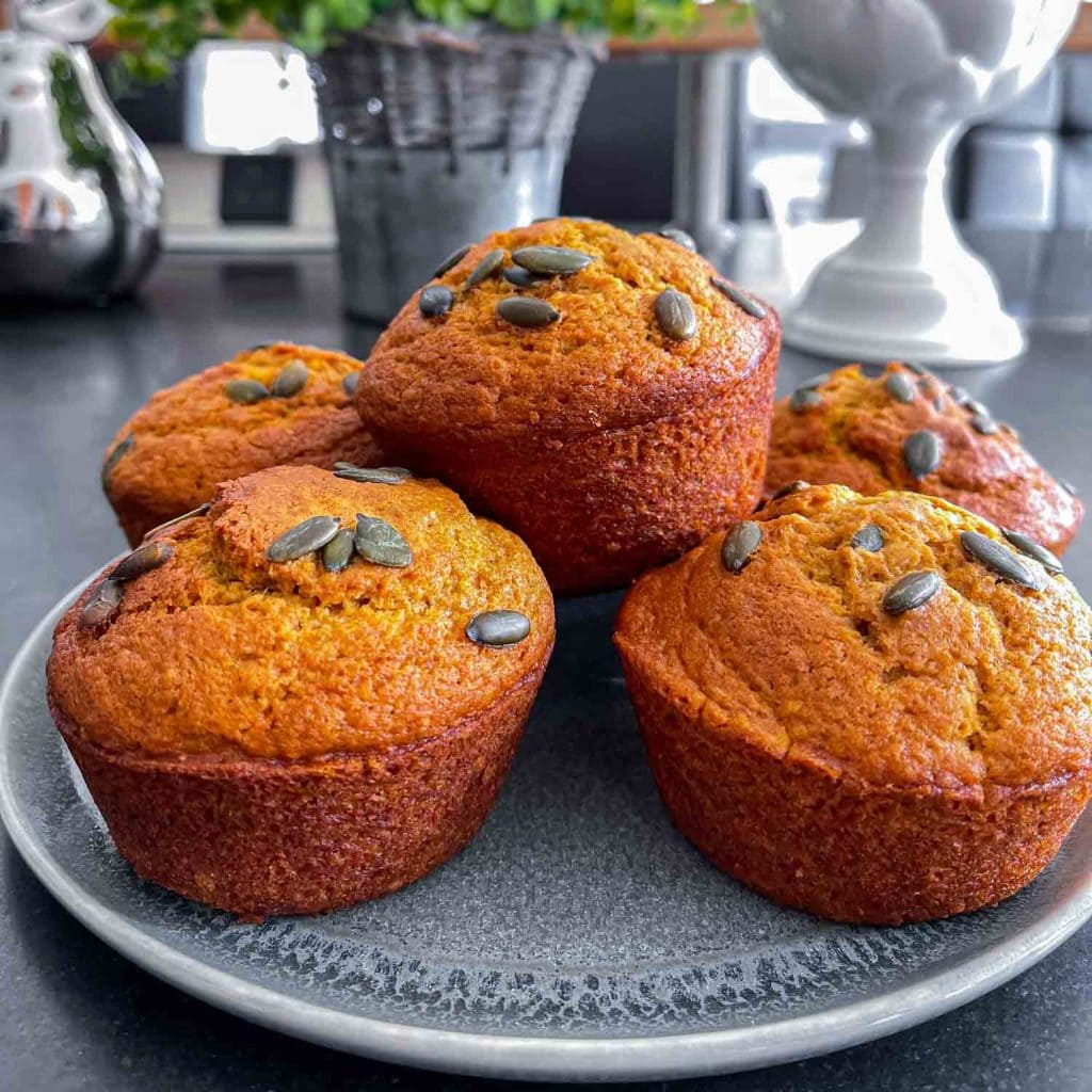 Golden pumpkin muffins, topped with pumpkin seeds.