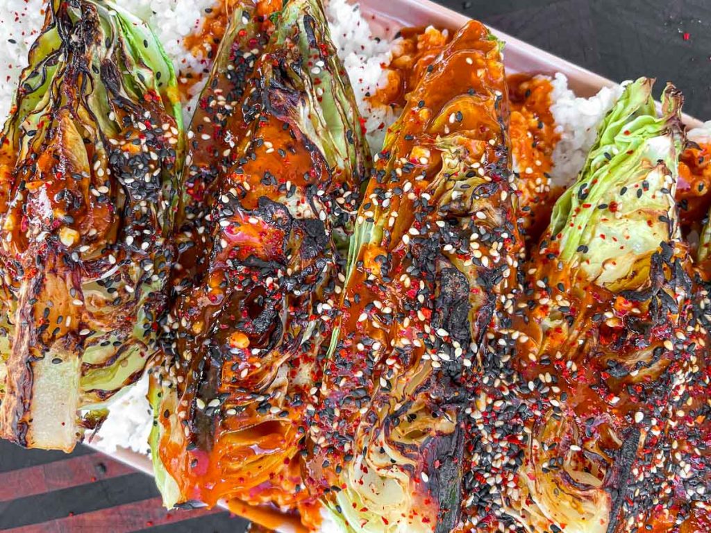 Charred cabbage, topped with a gochujang sauce, served over rice.