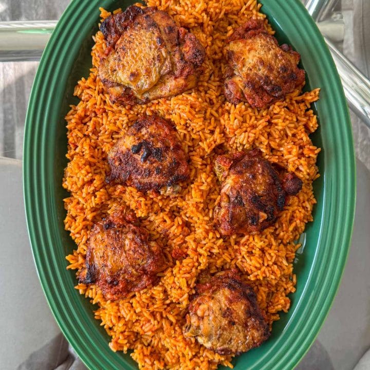 One pot jollof rice and chicken, served on a green platter.