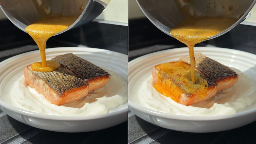 Pouring the sizzling hot spiced butter over the crispy salmon.