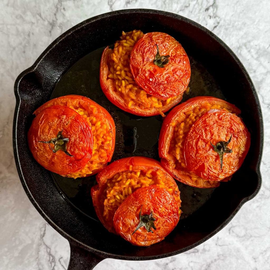 Rice stuffed tomatoes, straight out of the oven in a black cast iron pan.