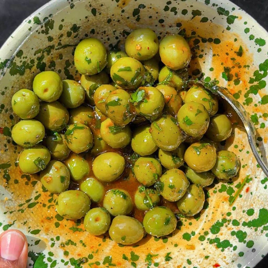 Close-up of olives coated in nduja oil marinade.