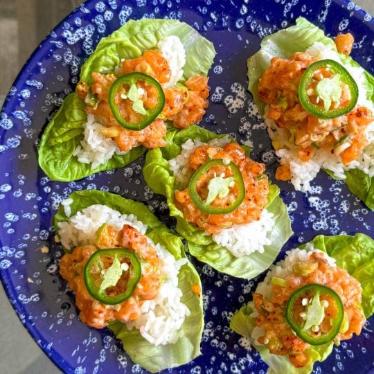 Close-up of Spicy Salmon Lettuce Cups showing diced salmon in creamy sriracha dressing inside crisp little gem leaves.