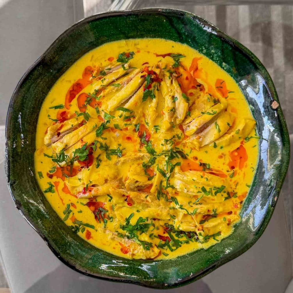 Tender poached chicken thighs in a rich saffron-infused coconut sauce.