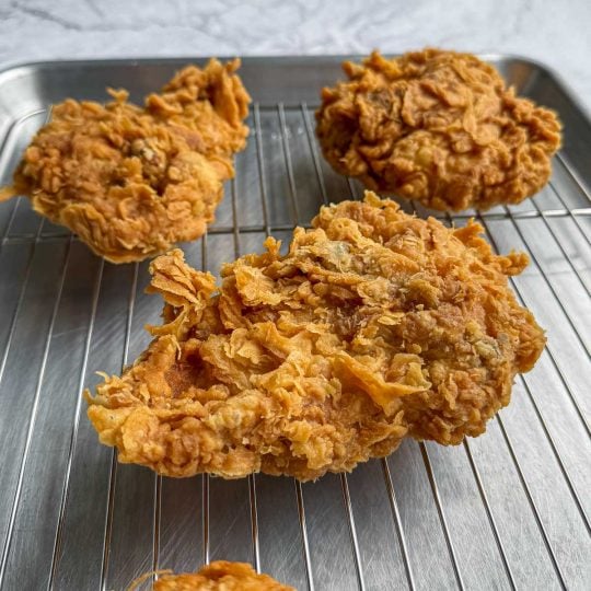 Side angle of Lemongrass Fried Chicken on rack, highlighting the crisp, uneven coating.