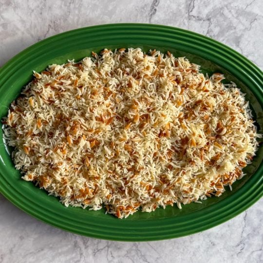 Lebanese-Style Rice made with orzo instead of broken vermicelli, served on a green platter.