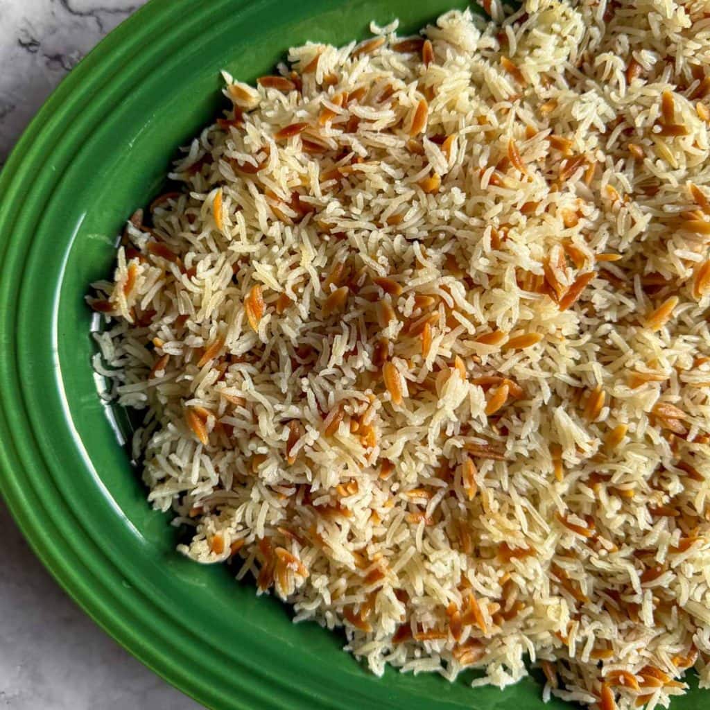 Close-up of Lebanese-Style Rice on a green platter showing fluffy grains and golden toasted orzo.