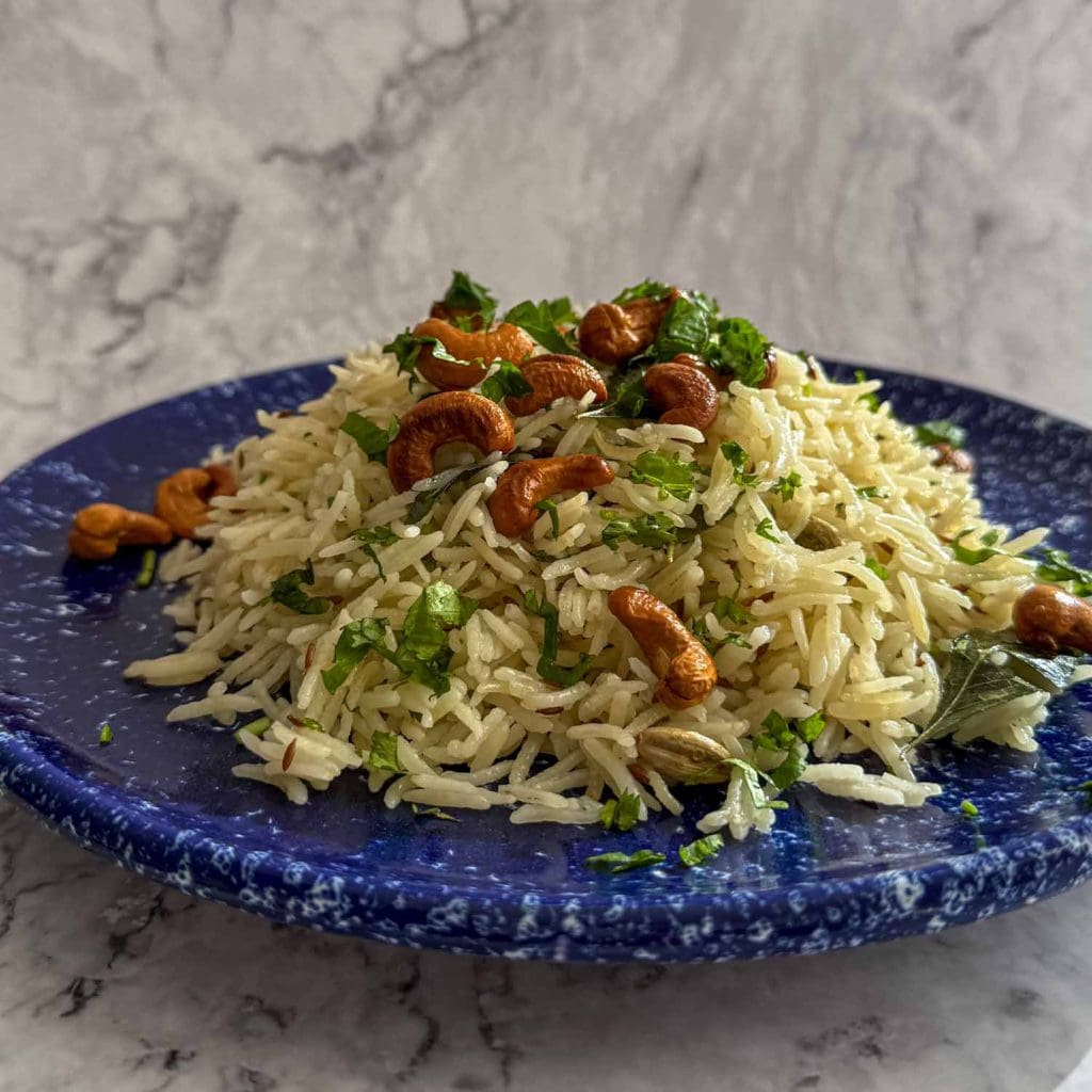 Spiced Curry Leaf Rice served on a speckled blue plate.