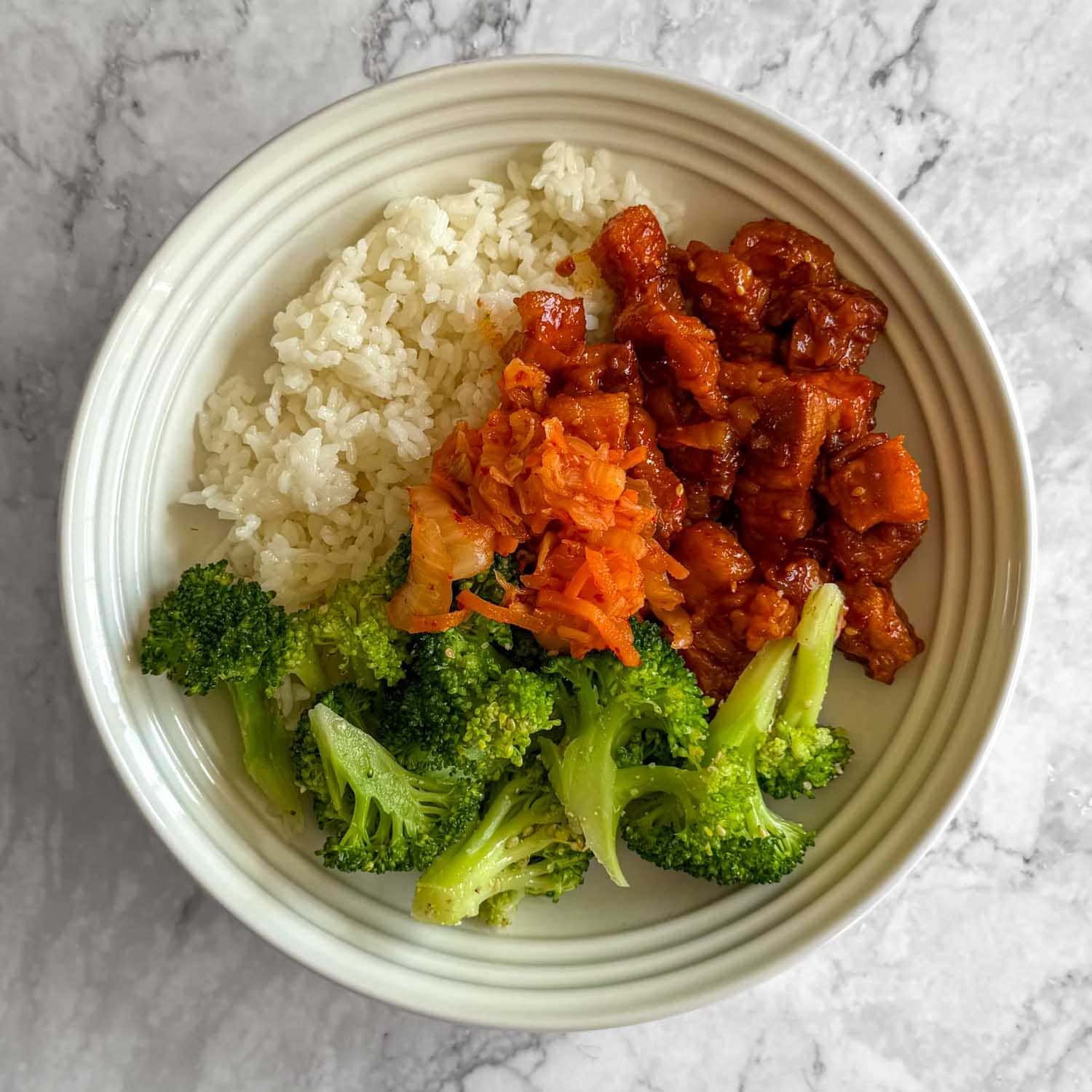 Sticky kimchi pork belly, served with rice, kimchi and sesame broccoli.