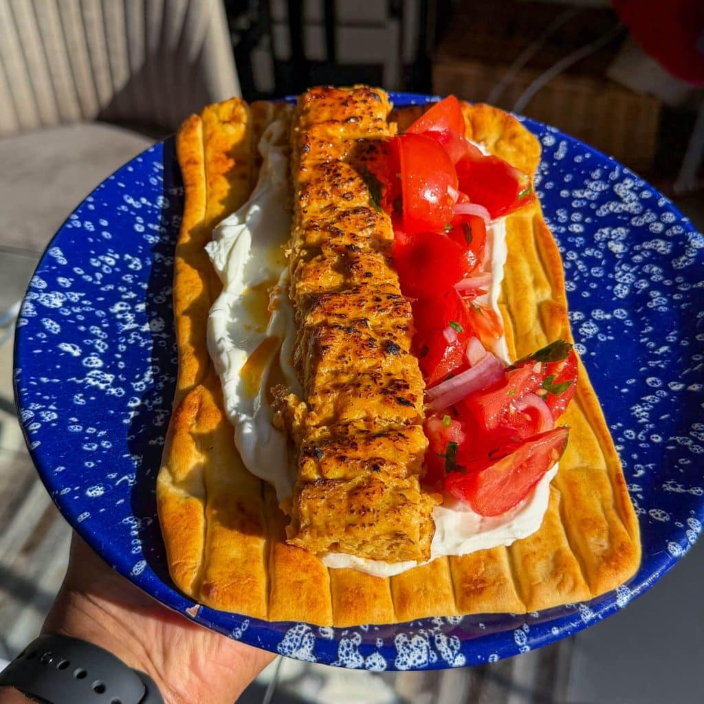 Sheet pan chicken kebab, served on a flatbread with yoghurt and a tomato salad.