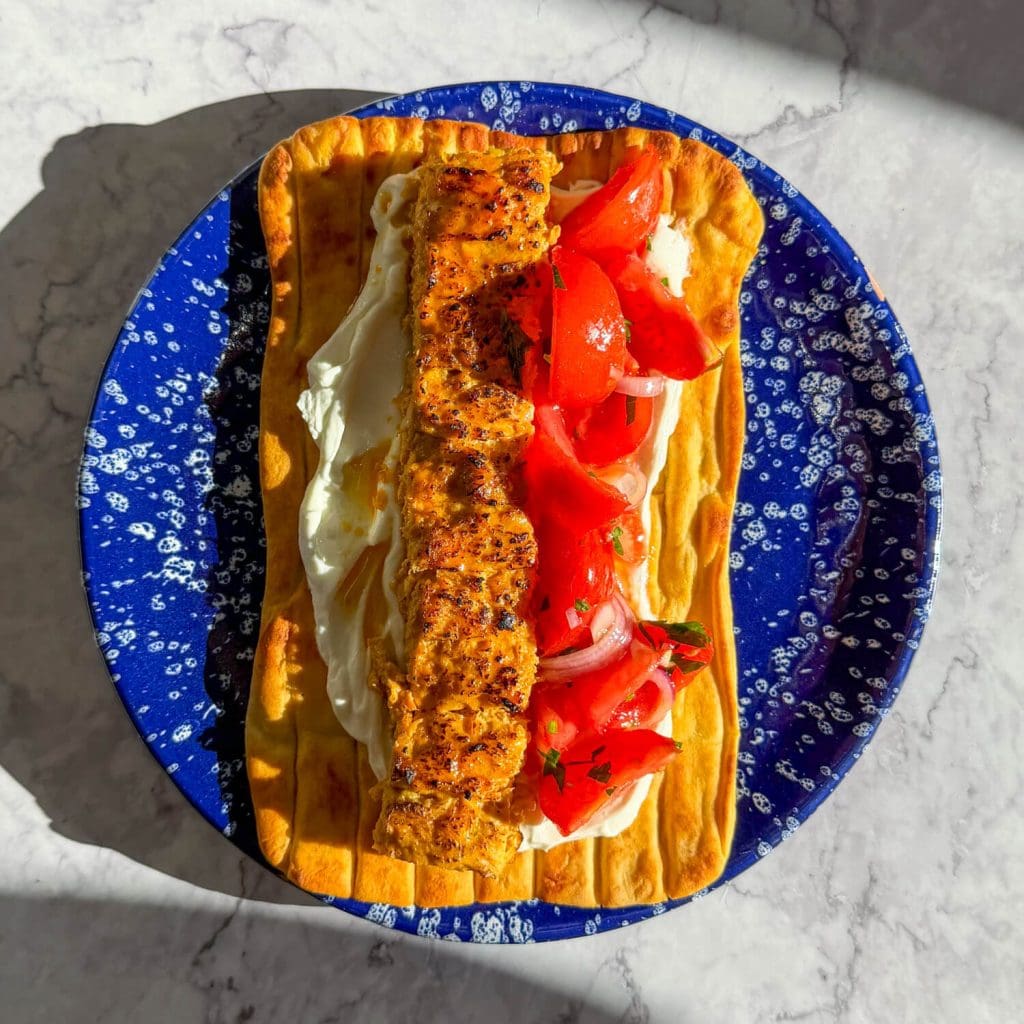 Sheet pan chicken kebab, served on a flatbread with garlic yoghurt and a tomato salad.