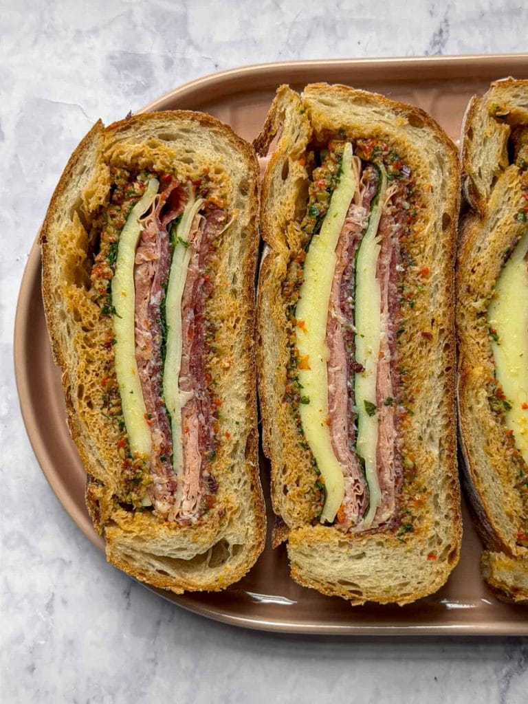 Pressed muffuletta sandwich with olive salad and Italian deli meats
