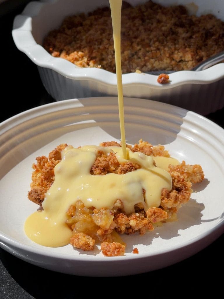 Pouring custard over the crumble.