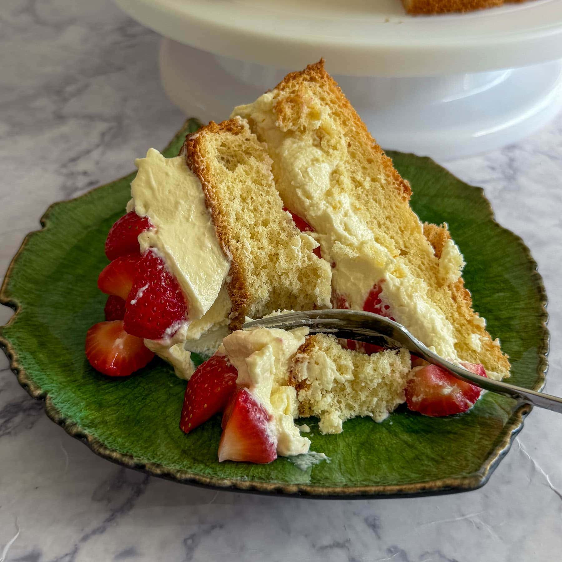 A closeup of the strawberry cloud cake with mascarpone cream, served on a green plate.