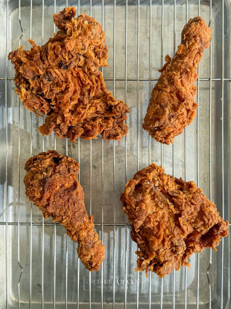 Golden tom yum fried chicken, resting on a wire rack