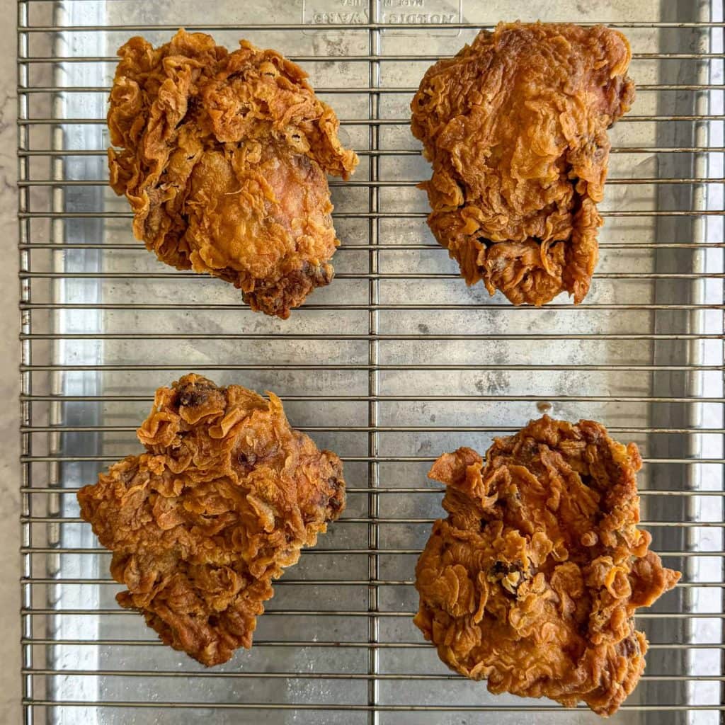 Tom yum fried chicken, draining on a wire rack.