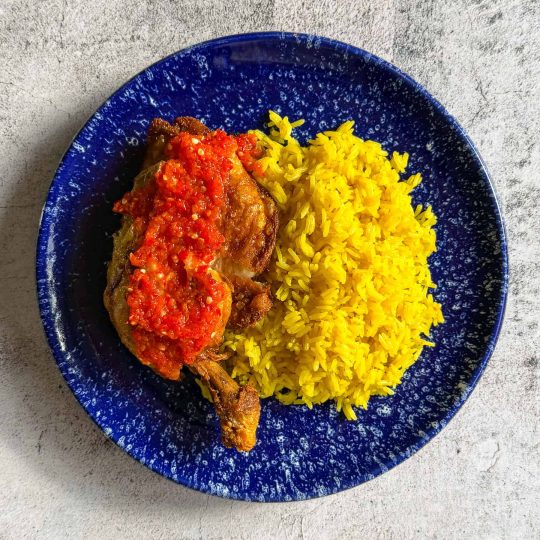 Ayam penyet Indonesian fried chicken served with spicy sambal and golden jasmine rice