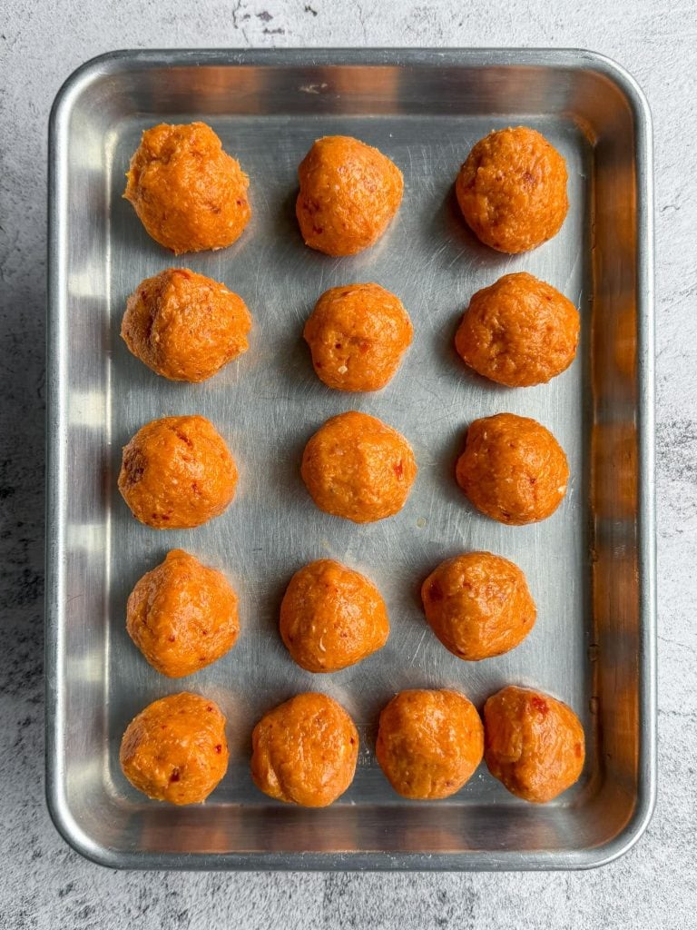 Rolled chicken balls on a baking tray
