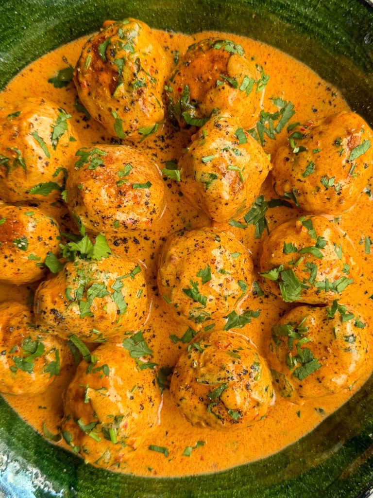 Coconut harissa chicken meatballs, with a close-up of the silky sauce coating the meatballs.