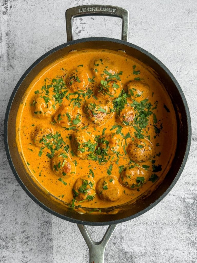 Coconut harissa chicken meatballs, in a black pan.