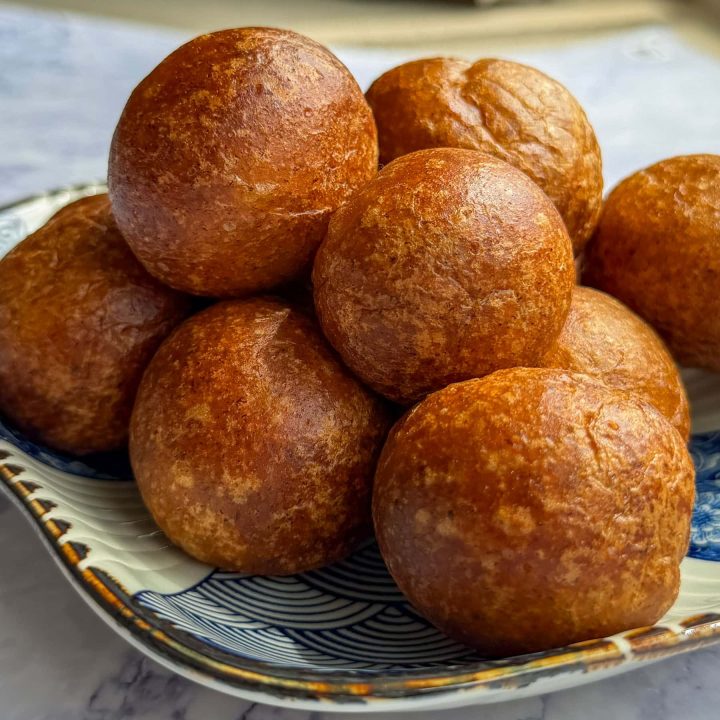 Golden puff puff, piled high onto a small plate